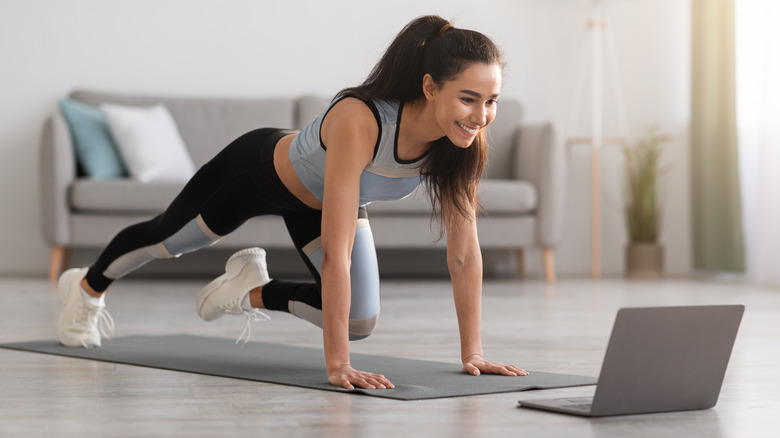 Woman watching computer while exercising