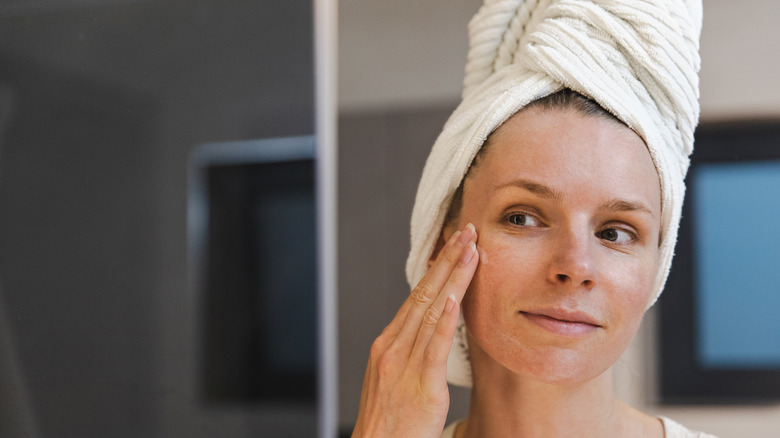 Woman applying skincare towel on head