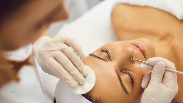 Esthetician using extraction tool during facial 