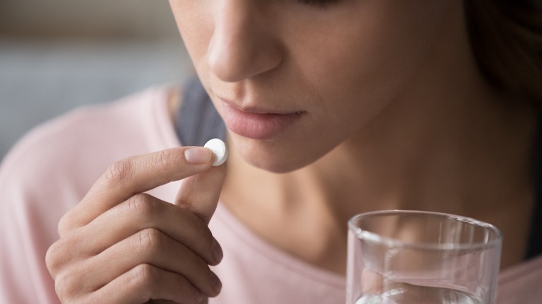 Woman taking pill with water