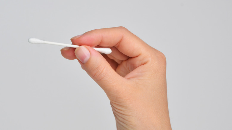 Woman holding cotton swab