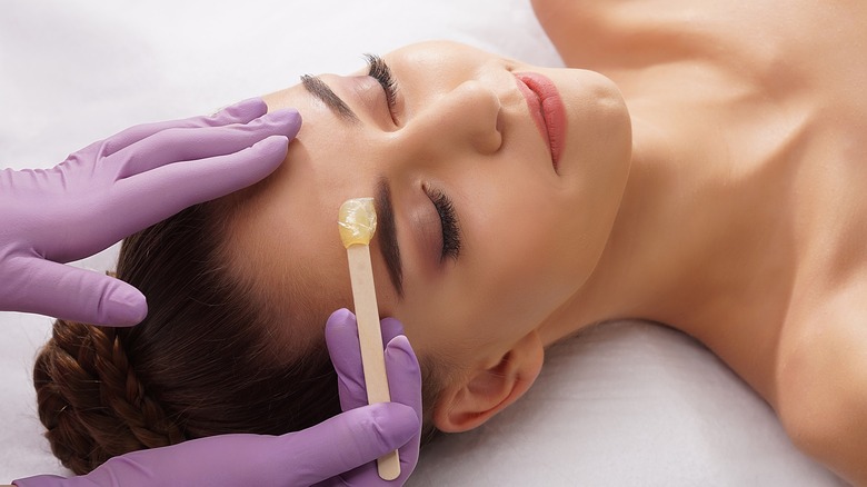 woman having eyebrows waxed