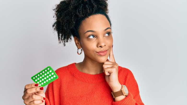 Woman holding birth control pack