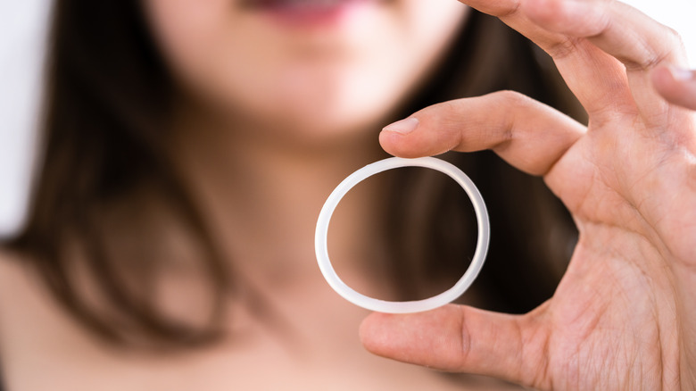 Woman holding a vaginal ring 