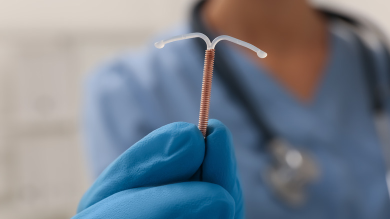 Doctor holding copper IUD 