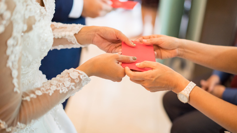 person giving gift to bride