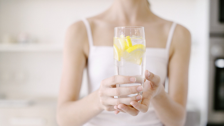 Woman holding glass of water