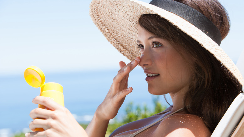 woman applying sunscreen outside