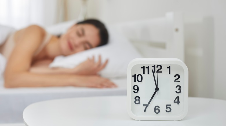 Person sleeping next to clock