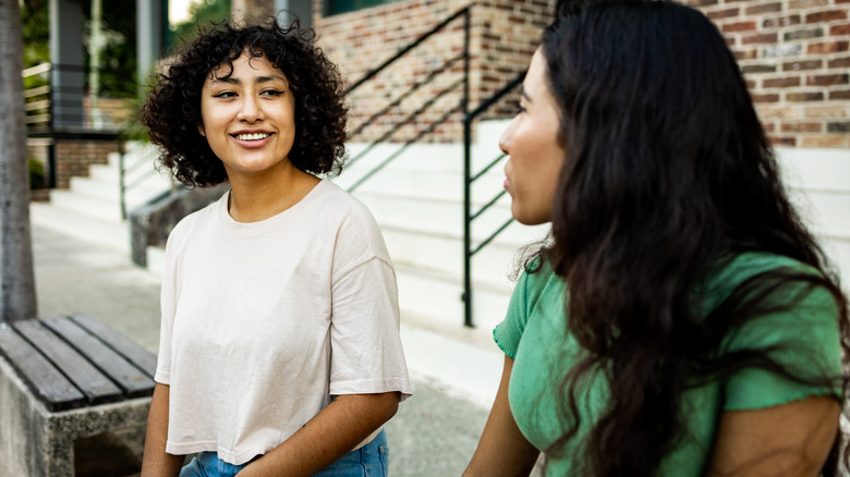 two women talking outdoors