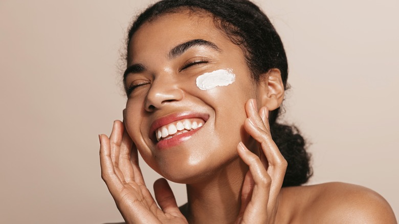 Smiling woman with face cream