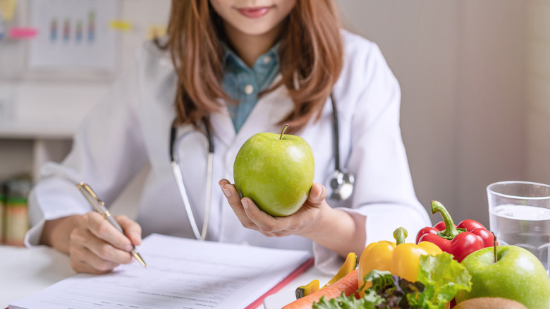 Clinician evaluating fruit and taking notes at desk