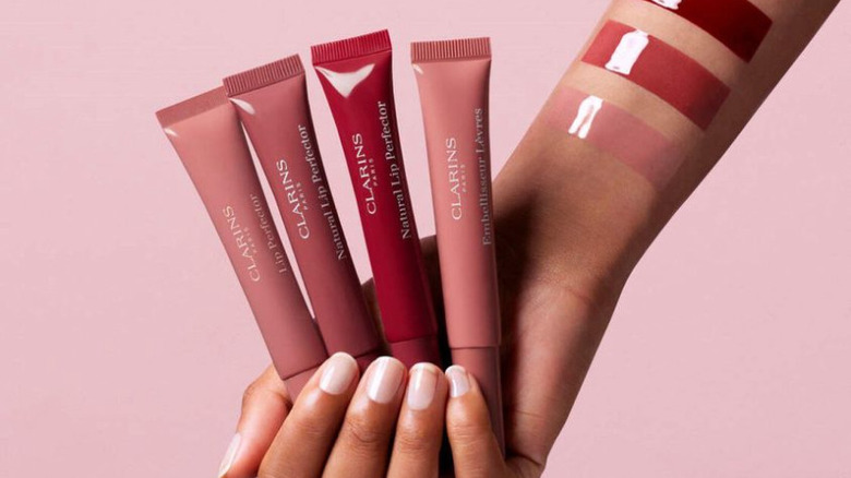 hand holding Clarins lip glosses