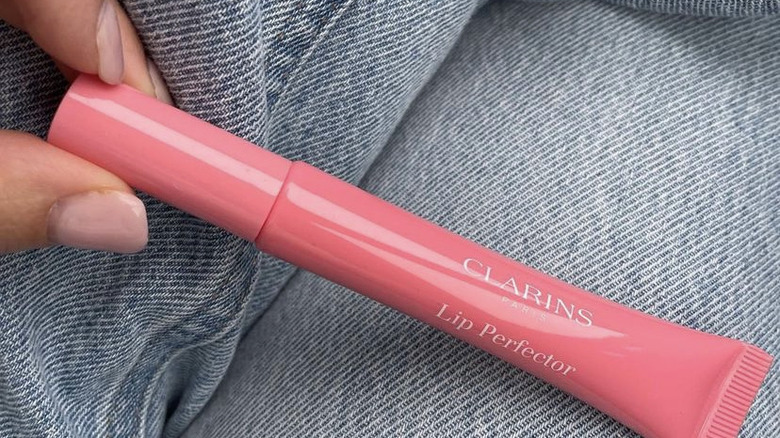 person holding Clarins lip gloss