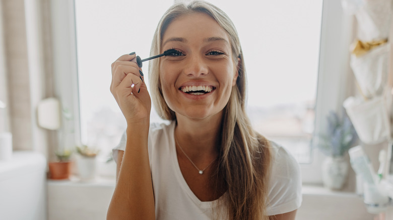 woman applying mascara to eyes