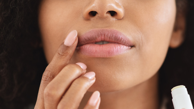 Woman applying chapstick to lips