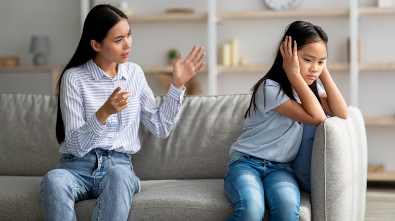 Daughter covers ears at mother