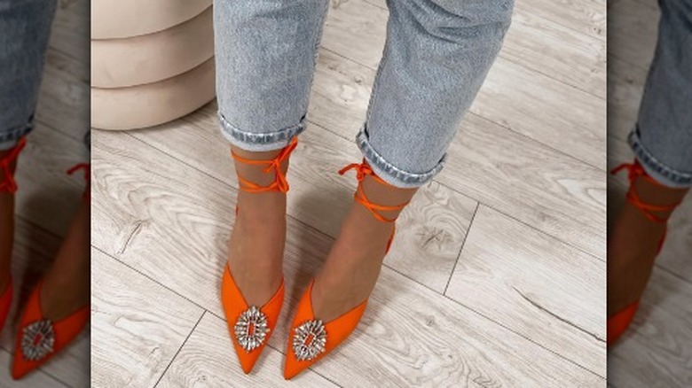Feet wearing neon orange shoes