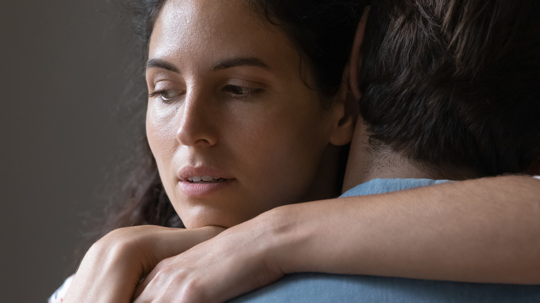 Unhappy woman hugging man