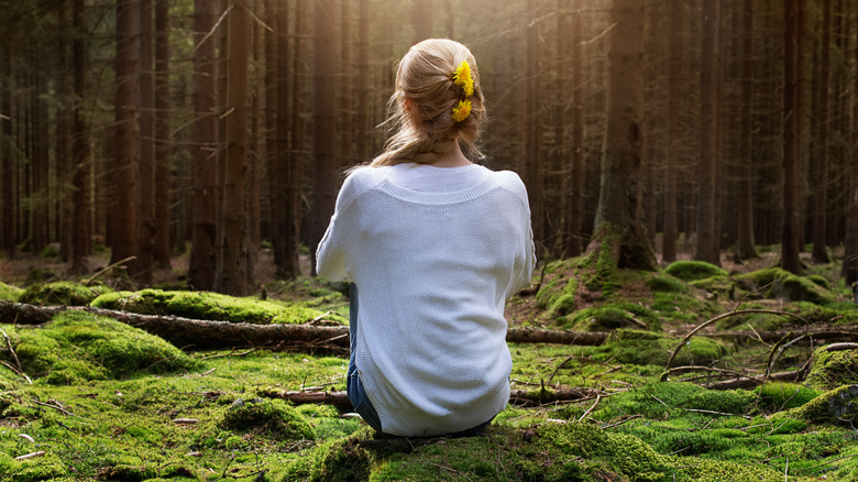 Peaceful woman sitting in forest