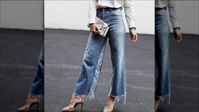 Woman wearing raw-hemmed jeans, heels