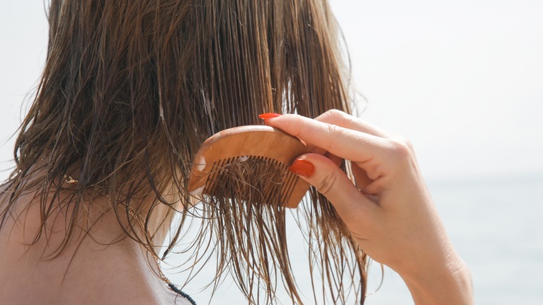 woman combing wet short hair