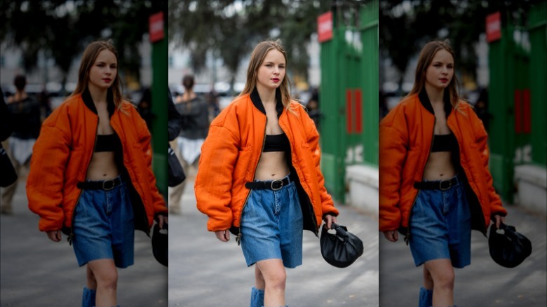 Woman wearing bomber jacket, bandeau, jorts