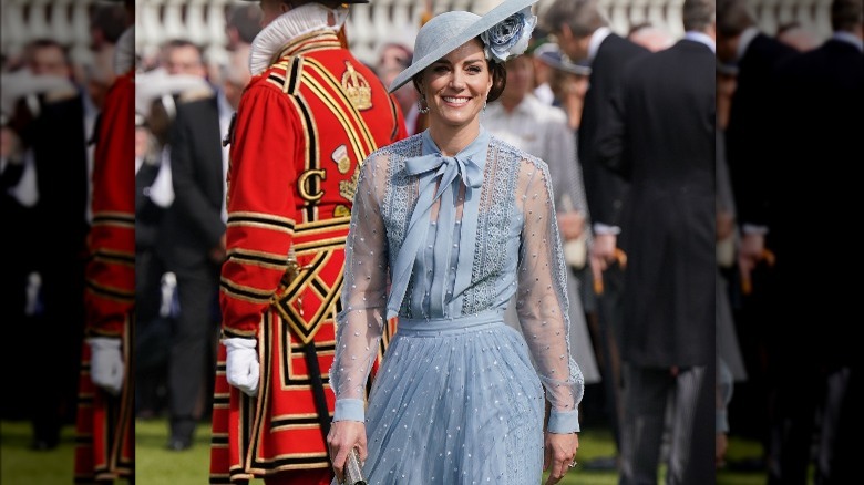 Kate Middleton smiling in dusty blue outfit