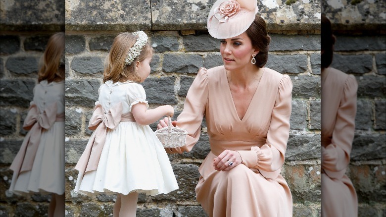 Kate Middleton in pink talking to Princess Charlotte