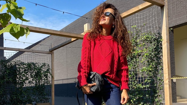 Girl wearing a scarlet cable knit sweater.