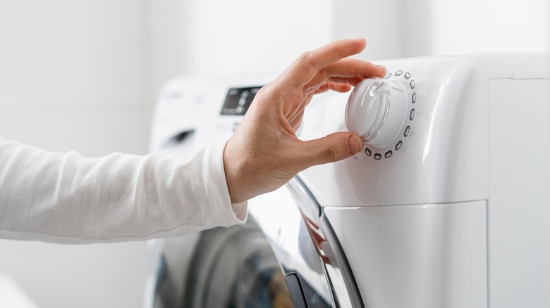 Person turning on a washing machine