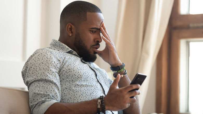 Man views phone with concern