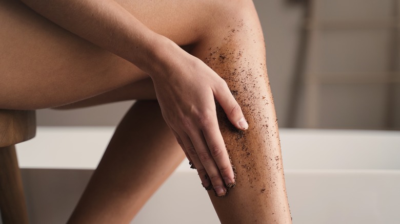 Woman exfoliating legs