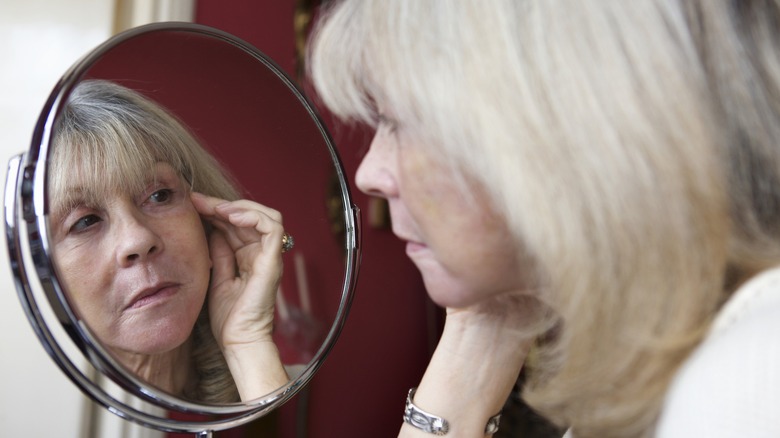 Woman inspects her nose 