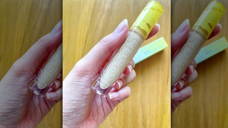 person holding Kosas concealer 