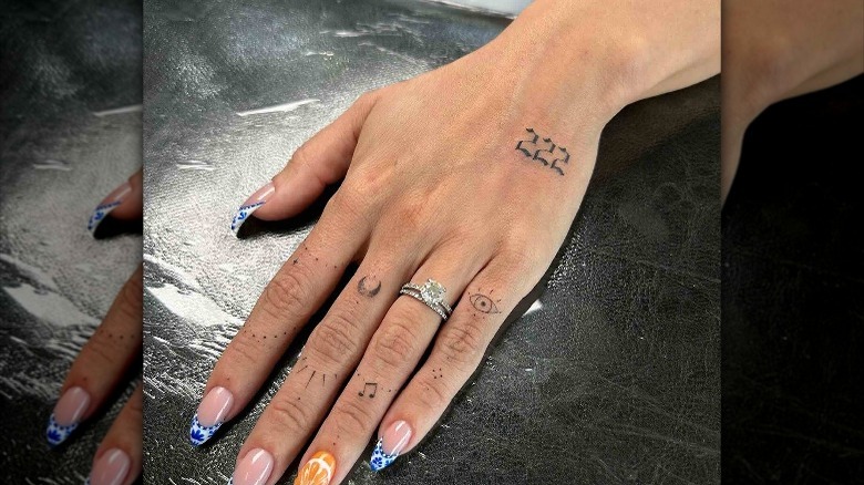 hand with "222" tattoo