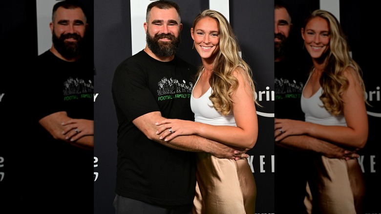 Jason and Kylie Kelce, in a gold skirt, smiling and posing together