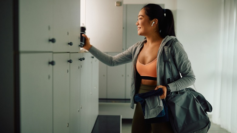 woman getting bottle from locker 