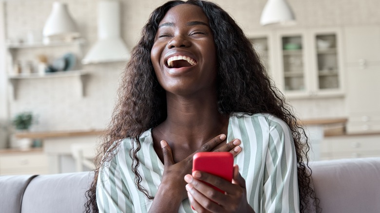 woman laughing at her phone