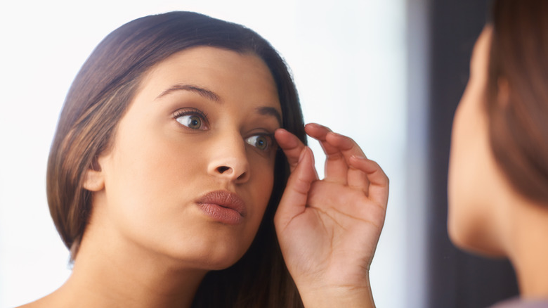 Woman looking at her eyelashes