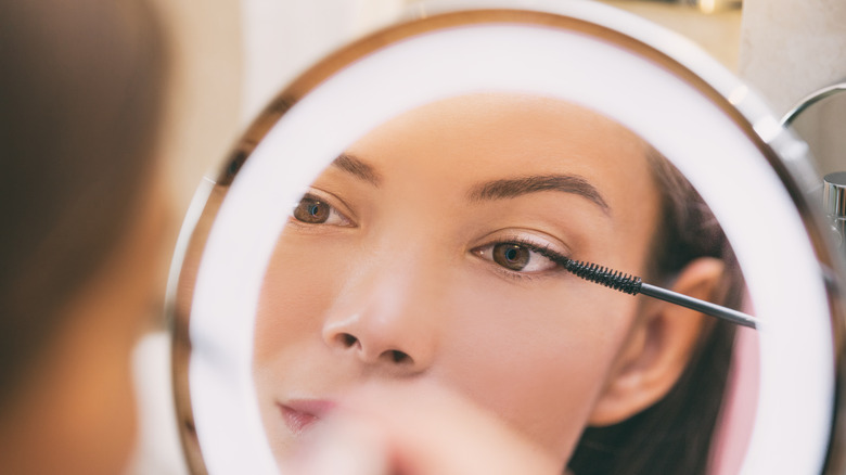 Person applying product to eyelashes