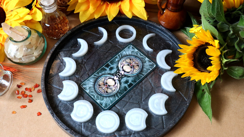 Altar with moon phases, sunflowers, and oracle card