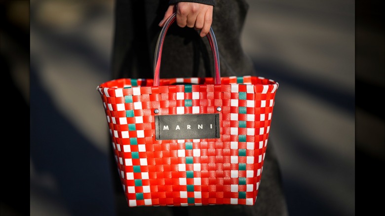 woman holding leather woven tote