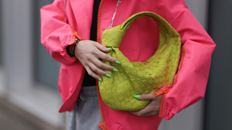 woman holding leather woven handbag