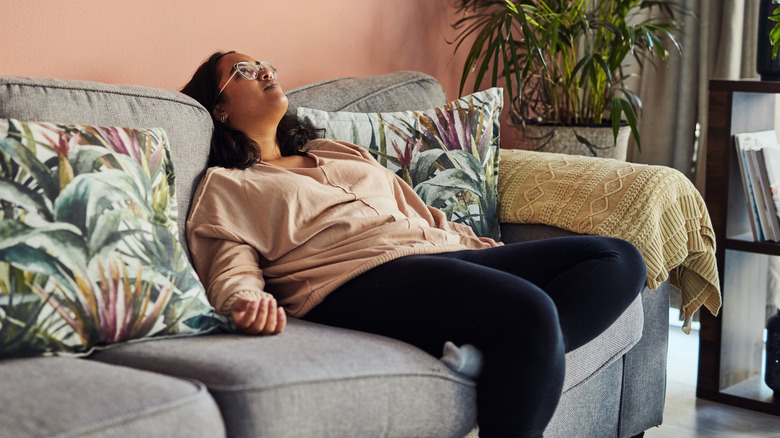 Exhausted woman reclining on sofa