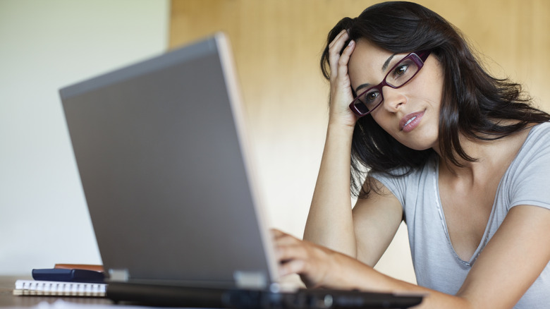 Woman thinking at her computer