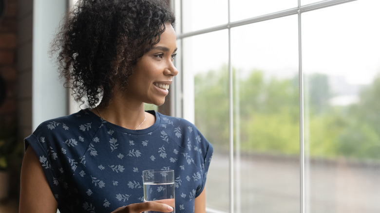 Young happy woman drinking water