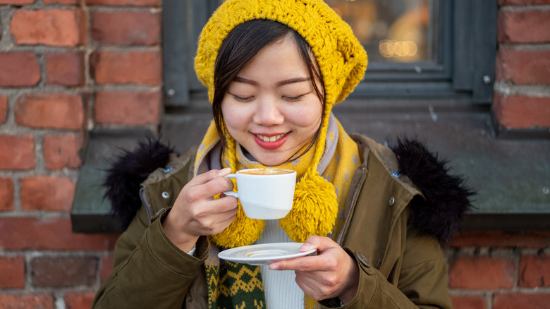 Smiling woman enjoying coffee outside