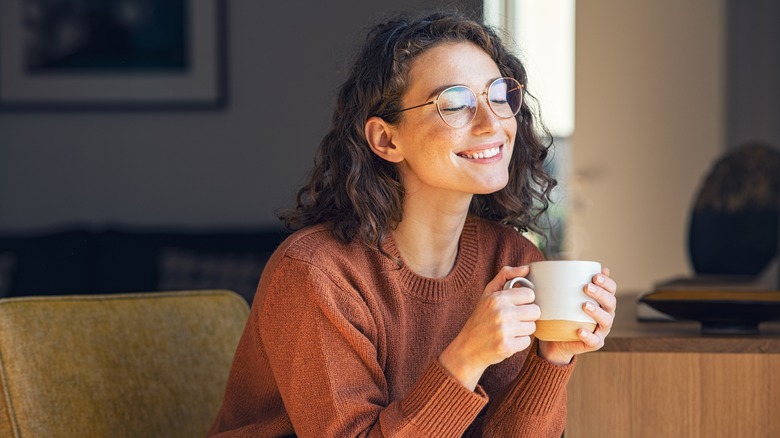 Woman drinking tea, looking happy