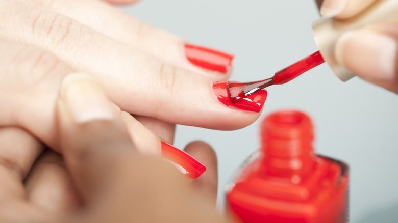 Red nail polish being applied